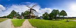 Windmühle Levern (Stemwede) mit Fachwerkhäusern bei blauem Himmel mit weißen Wölkchen