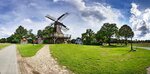 Windmühle Levern (Stemwede) mit Fachwerkhäusern bei grau-blauem Himmel